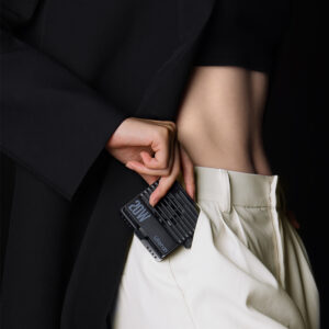 Ulanzi LE20 being slipped into a trouser pocket showing ultra-portable pocket-friendly design with 20W branding and ventilation grilles visible